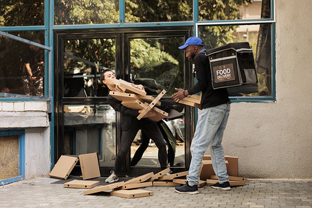 震惊的送餐顾客接住掉落的披萨盒堆