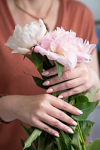 有花有海摄影照片_女孩的手有漂亮的粉色美甲设计，柔和的色彩，轻轻地，花