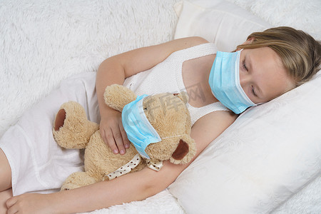 一个生病的少女戴着防护面具在玩玩具。