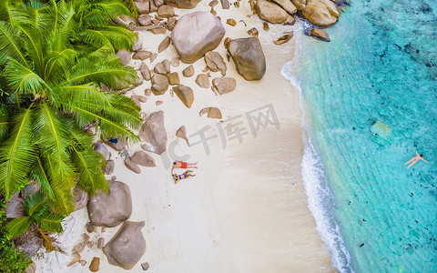 从上方无人机俯瞰塞舌尔普拉兰岛安塞拉齐奥海滩，海滩上的情侣男女
