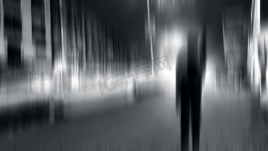 一个人在夜间站在路上的运动模糊图像。