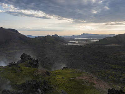 冰岛高地 Fjallabak 自然保护区日出时 Landmannalaugar 的熔岩场景观和地热喷气孔、河流三角洲和 Rhyolit 山