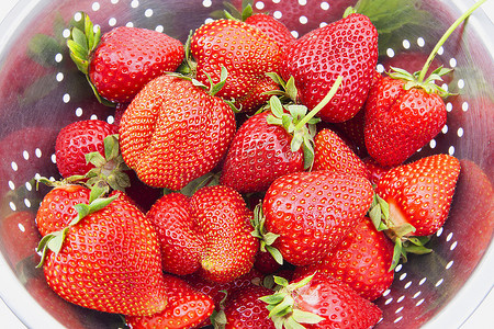 洗草莓草莓摄影照片_在漏勺顶视图的甜成熟美丽的草莓