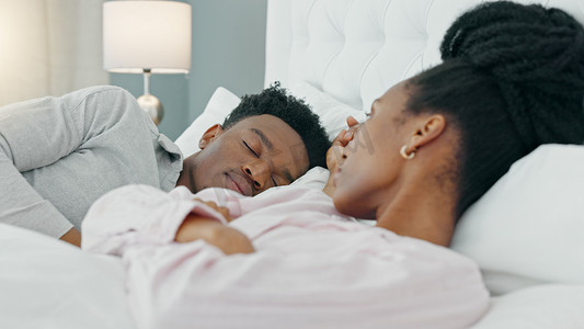 女性生气摄影照片_离婚，生气，和一个失眠的悲伤女人上床，她在家里的卧室里对着熟睡的丈夫摇头。