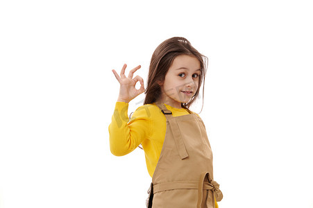 厨师围裙的白人女孩，儿童咖啡馆的小女服务员，用 OK 手势做手势，表达积极情绪