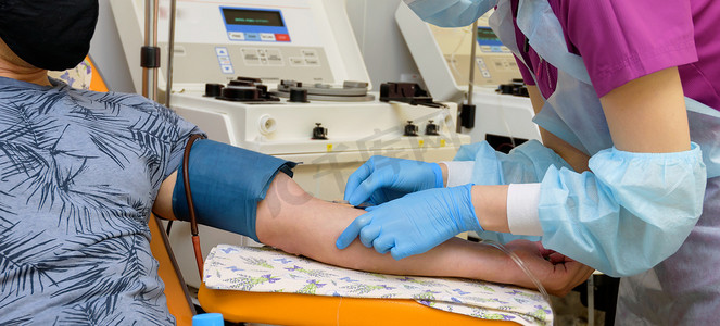 一名坐在扶手椅上的献血者在输血站献血