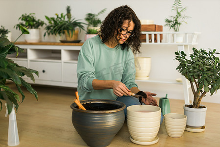妇女在家种植盆栽植物，浇水和补花 — 园艺和室内植物护理概念