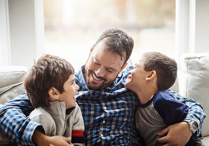 家庭住宅、男孩和爸爸在沙发上拥抱，为童年发展进行交谈、爱或结合。