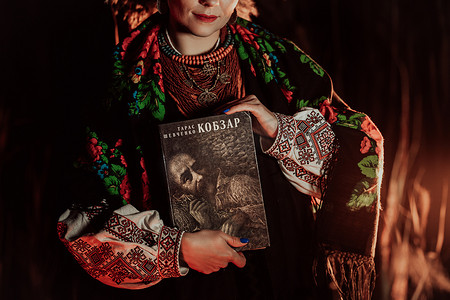 乌克兰基辅 — 2023 年 2 月。有塔拉斯舍甫琴科科布扎尔诗集的女人