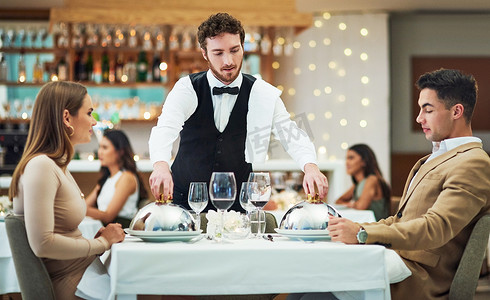餐厅、美食和情人节，一对夫妇在餐桌旁一起庆祝爱情、浪漫或婚姻。