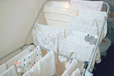 婴儿的衣服、紧身衣裤和裤子在洗衣后晾干。