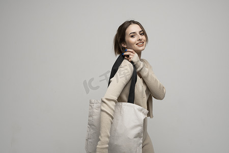 购物袋样机摄影照片_黑发年轻女孩拿着亚麻购物袋，模拟。