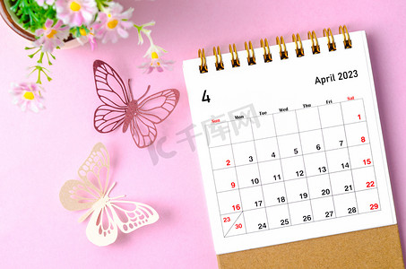 2023年4月摄影照片_2023 年 4 月的台历，供组织者计划和提醒，并在粉红色背景上画蝴蝶。