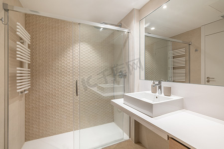 宽敞的现代瓷砖浴室内部配有白色水槽、大镜子和淋浴区。