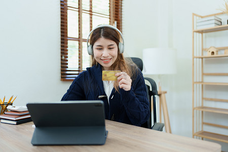 在线购物和互联网支付，美丽的亚洲女性正在使用信用卡和平板电脑笔记本电脑在线购物或在数字世界中办事