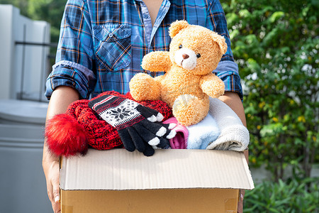 女志愿者提供装有旧衣服和洋娃娃的衣物捐赠箱，以支持对世界各地难民、无家可归者或穷人的帮助。