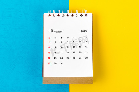 2023蓝色背景摄影照片_2023 年 10 月蓝色和黄色背景的 2023 年月度台历。