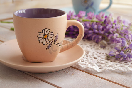 咖啡豆花摄影照片_杯黑咖啡和粉红色紫色羽扇豆花。