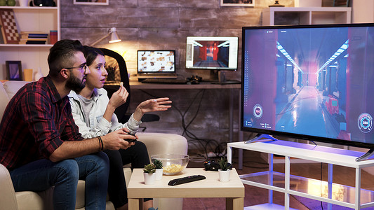 沙雕视频摄影照片_坐在沙发上的男人在电视上玩电子游戏