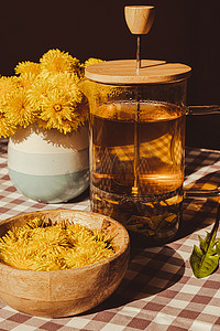 在桌上的玻璃杯中准备蒲公英花健康茶。