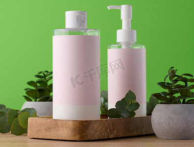 两瓶化妆品，绿色背景上贴着粉色纸标签。