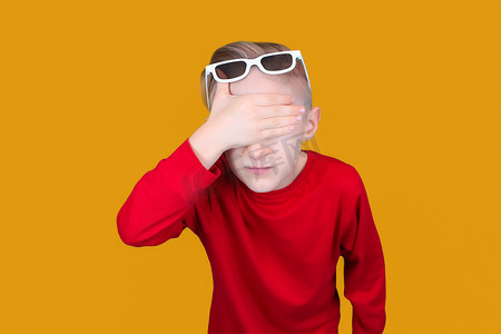 一个戴着儿童 3D 眼镜的孩子用手遮住了眼睛