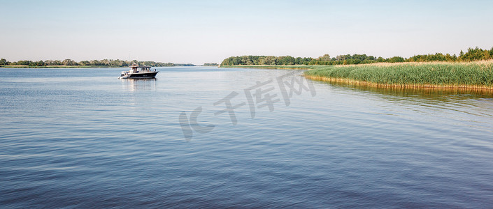 夏日正午阳光明媚，小船在蓝色泻湖中航行。