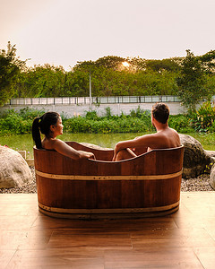 泰国乡村木浴缸里的男女情侣看日落