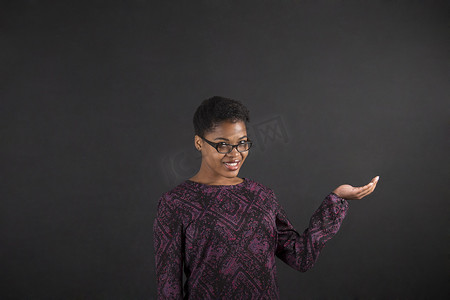 伸出手摄影照片_非洲妇女在黑板背景上伸出手