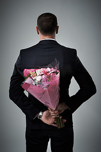 情人节，一个穿着西装的男人的惊喜和鲜花，背后有爱。