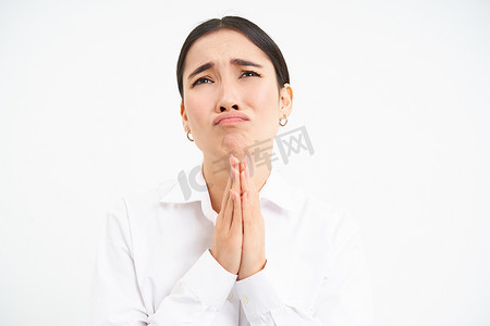 心烦意乱的亚洲女人带着绝望和悲伤的脸抬头，向上帝抱怨，站在白色背景上