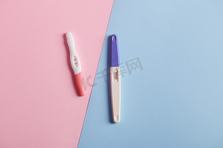 妊娠试验呈阳性，孤立的双色粉色和蓝色背景。