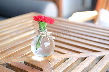 木桌上玻璃瓶花瓶中的红花