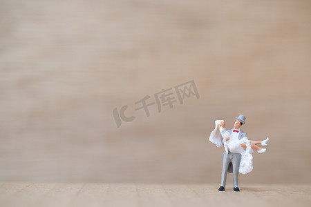 微型人物：木制背景中的新娘和新郎与警察