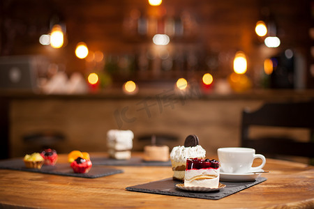 咖啡店木桌上不同口味的蛋糕组合