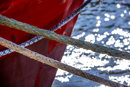 黑暗系摄影照片_带水反射的拖网渔船系泊缆