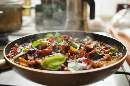 炸锅食品摄影照片_健康食品蔬菜在平底锅中油炸番茄茄子洋葱胡椒西葫芦