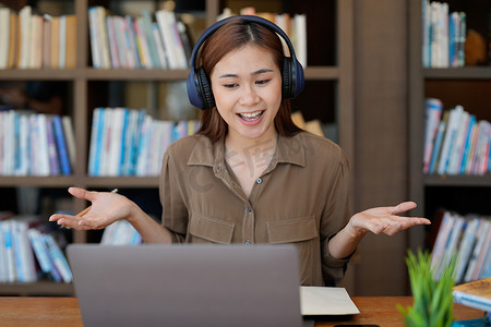亚洲语言导师开始在线课程，学员挥手微笑着看着电脑屏幕。