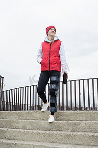 腿部手术后戴护膝或矫形器的妇女在公园散步