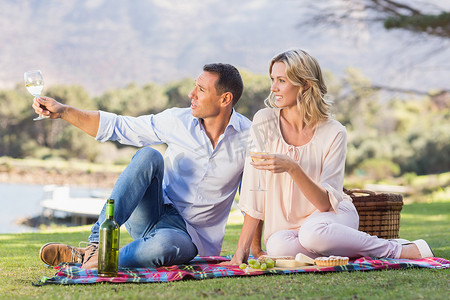 微笑的夫妇坐在野餐毯上欣赏美景