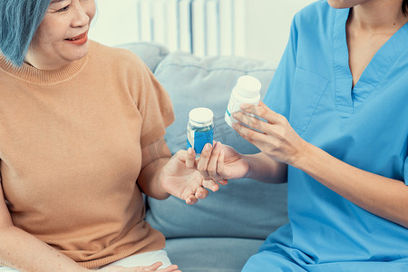照顾者在客厅里为心满意足的老年妇女提供服药建议。