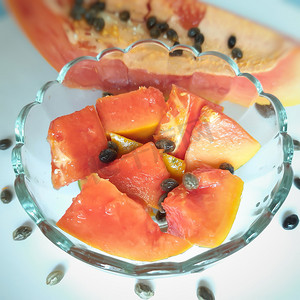 橙色鲜木瓜保存在白色背景中，碗中有切块，富含纤维 维生素 C 和抗氧化剂 增强免疫力 对糖尿病患者和眼睛有益