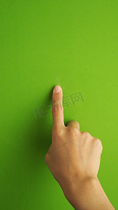 屏幕手势摄影照片_人的手指触摸或指向绿色屏幕。