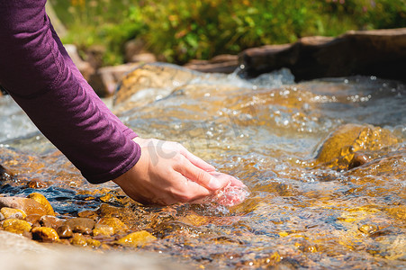 健康水源摄影照片_女手特写从山涧汲水解渴，喝干净的水源。