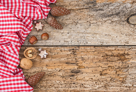 方格边框摄影照片_旧木背景上的乡村圣诞装饰，带红色格子织物边框