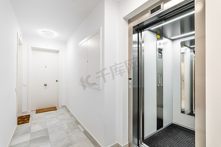 现代可靠的室外电梯，可以看到新公寓楼的大厅和公寓门。