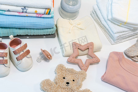 白色桌子上的婴儿衣服和配饰的顶部视图。