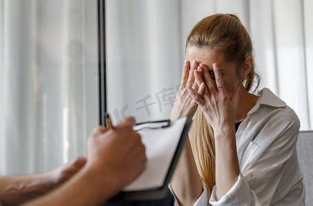 全科医生摄影照片_一位男性心理学家咨询一位女性患者，做笔记。