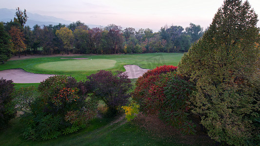 人们在秋天的绿色田野上打高尔夫球