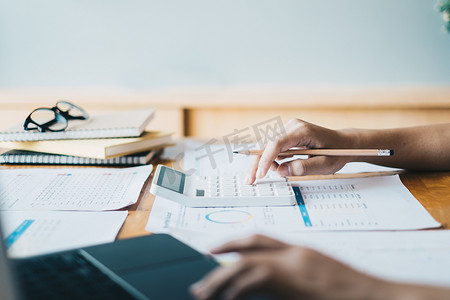 特写女商人使用计算器在办公室、税务、会计、统计和分析研究概念的木桌上审计财务预算。